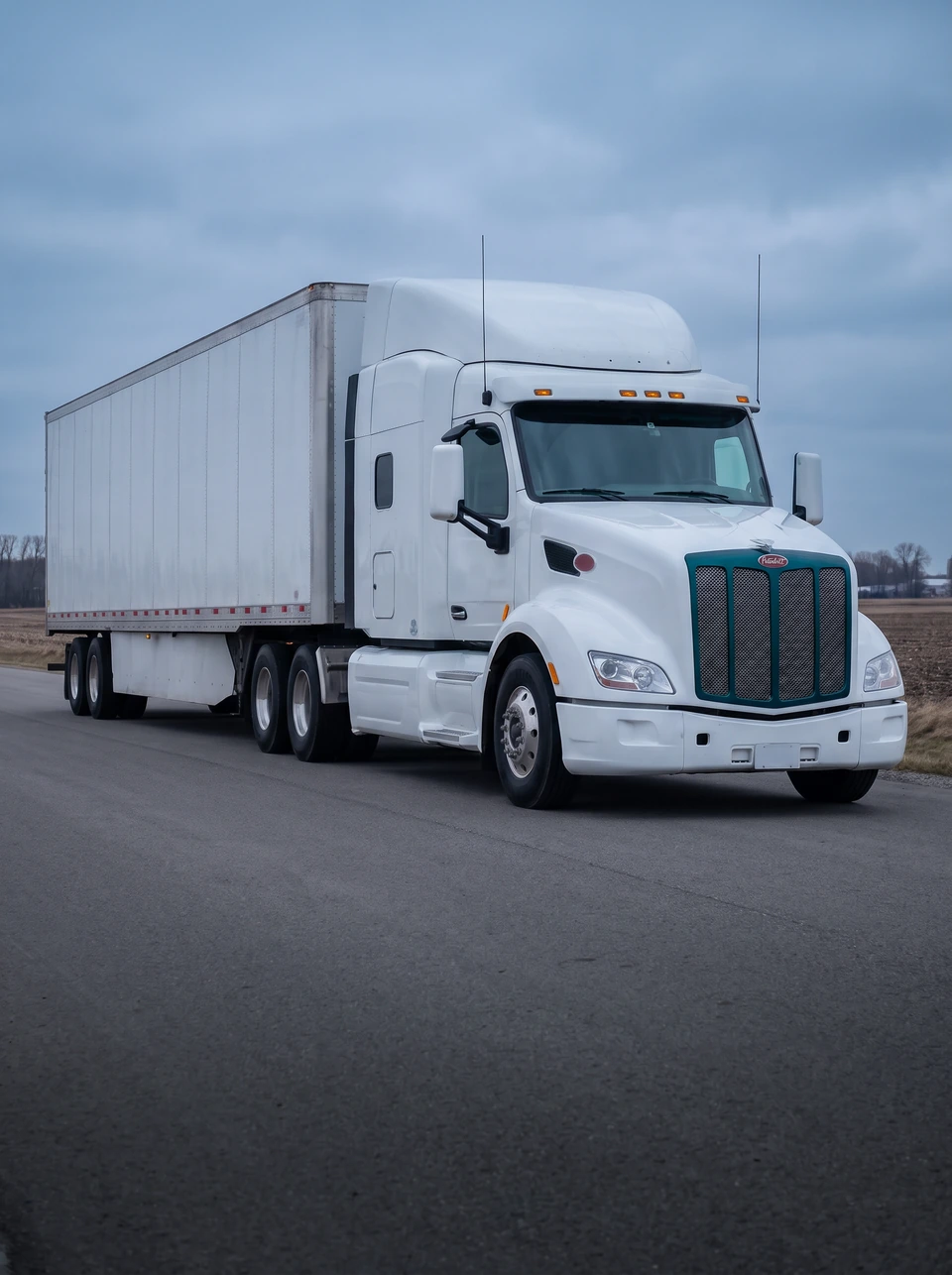 Semi truck with a dry van trailer on an industrial road