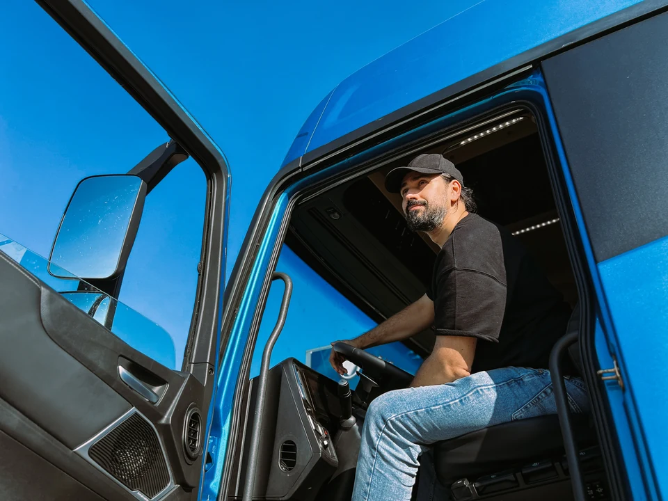 Truck driver seated in a blue tractor cab