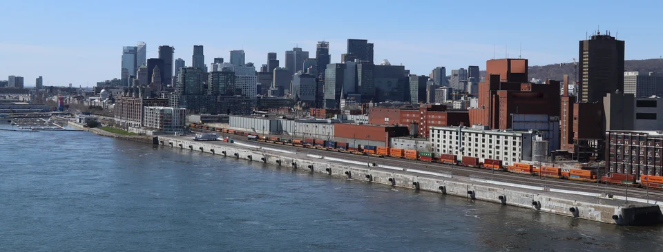 Port of Montreal wharf with container trains on the quay and the downtown skyline behind